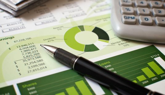 Close up of report with green charts and pen