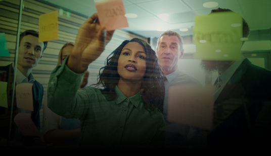 business people looking at whiteboard with post-it notes